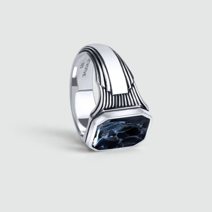 Bariq sterling silver mens signet ring facing down, showing the blue pietersite stone and engraved 925 hallmark.