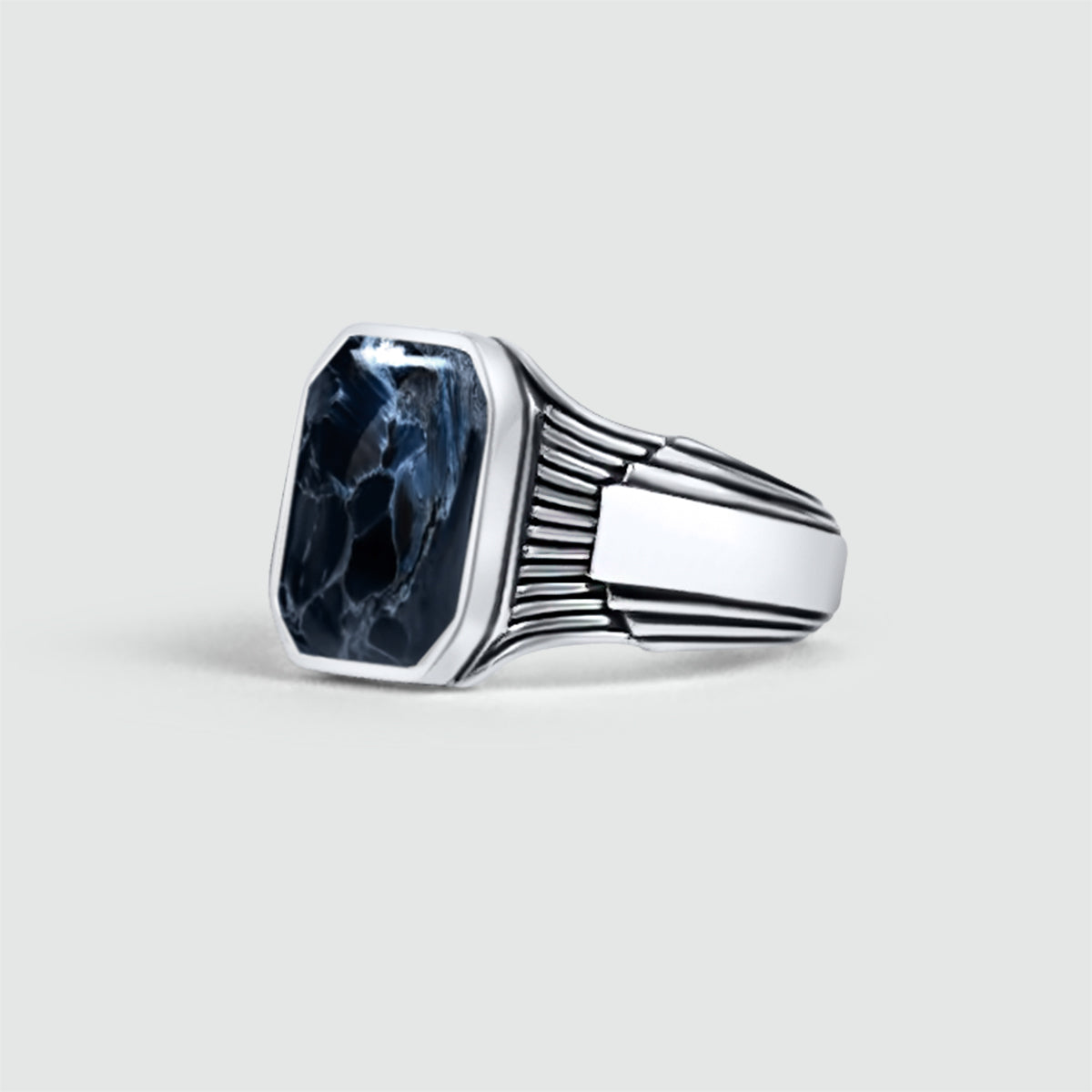 Close up view of mens signet ring with a Bariq blue pietersite stone in the center.