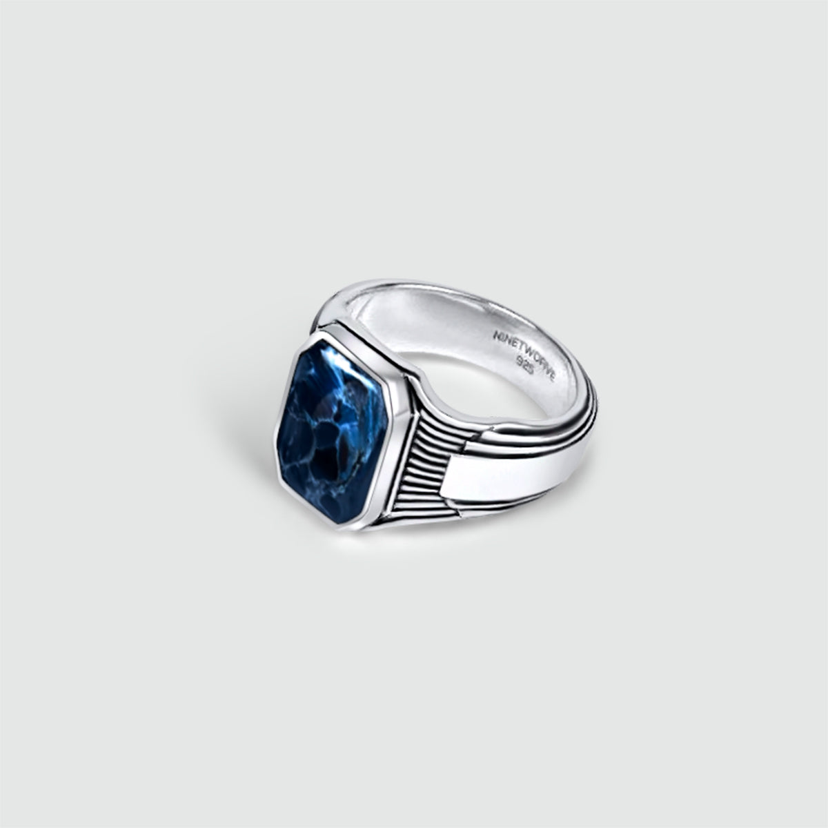 A Bariq sterling silver mens signet ring with a blue topaz stone, showcasing engraved 925 and NineTwoFive hallmark.